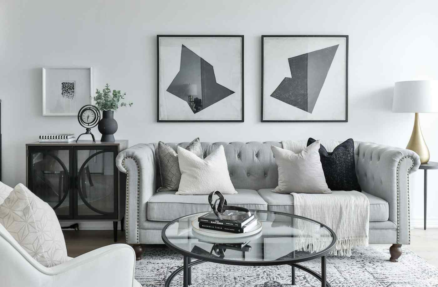 A living room with framed art above a grey sofa