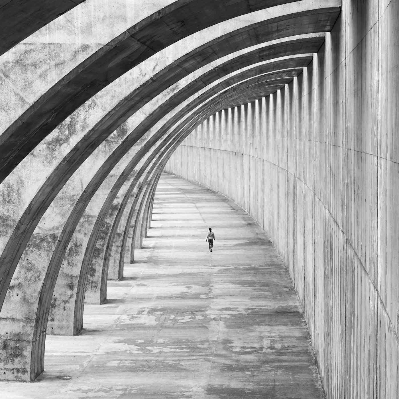 Curved concrete arches with a lone walker